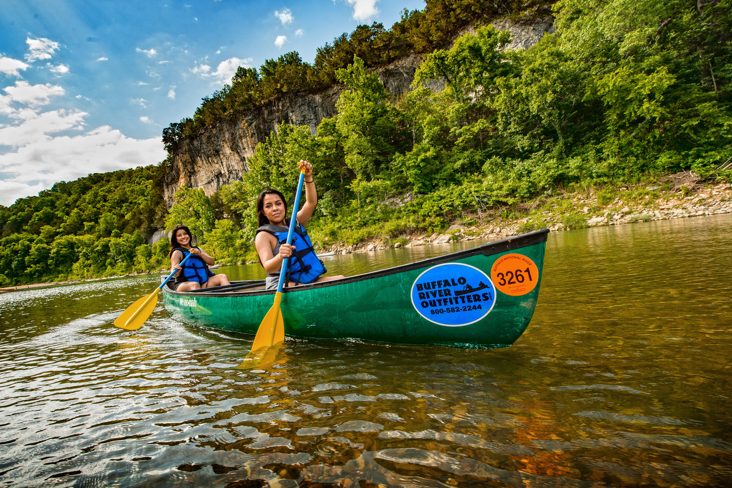 Two canoers paddle along the serene waters of the Buffalo River