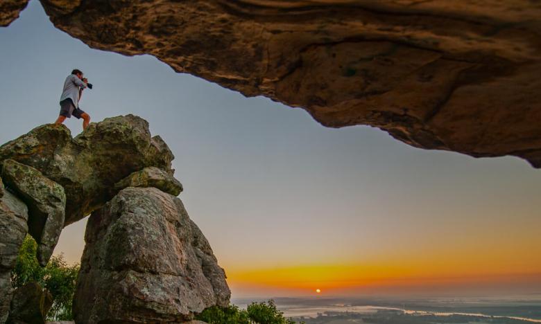 Photographer on top of Rock at sunset